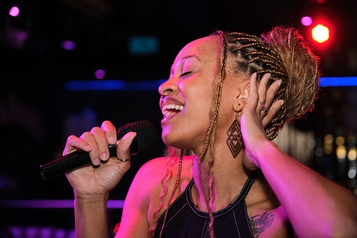 Woman singing into a microphone at a trendy nightclub