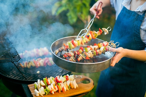 Grilling up healthy chicken and vegetable kebabs at a backyard barbecue!